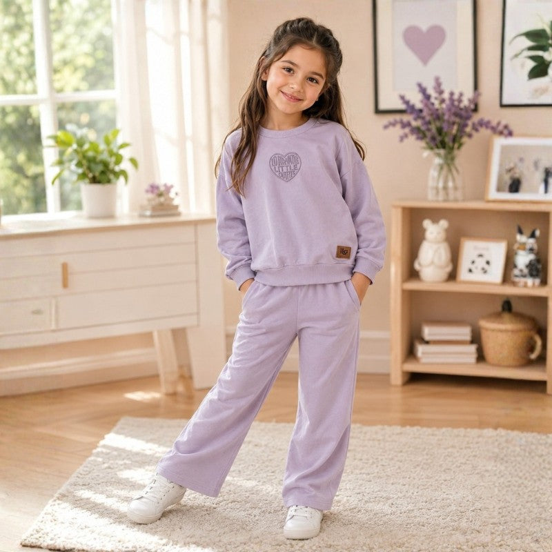 Girl wearing a lavender sweatshirt with matching wide-leg pants 