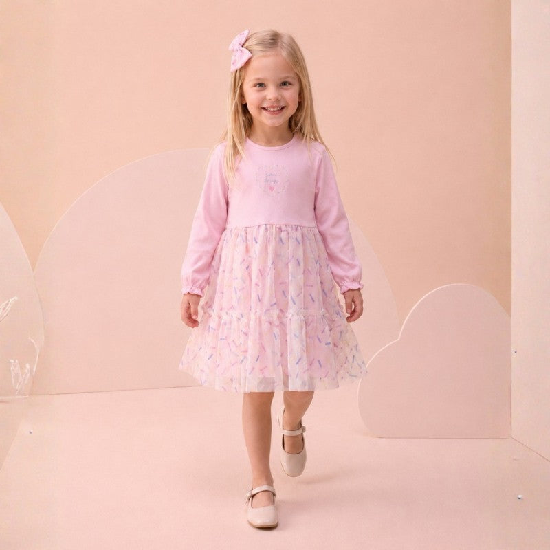Girl wearing a long-sleeve dress with floral tulle skirt and bow hair accessory