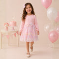 Girl wearing a pink long-sleeve party dress with a pastel tulle skirt and bow 