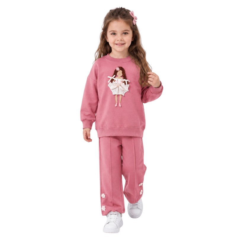 Young girl wearing a rose gold ballerina sweatshirt and matching pants in a dance studio