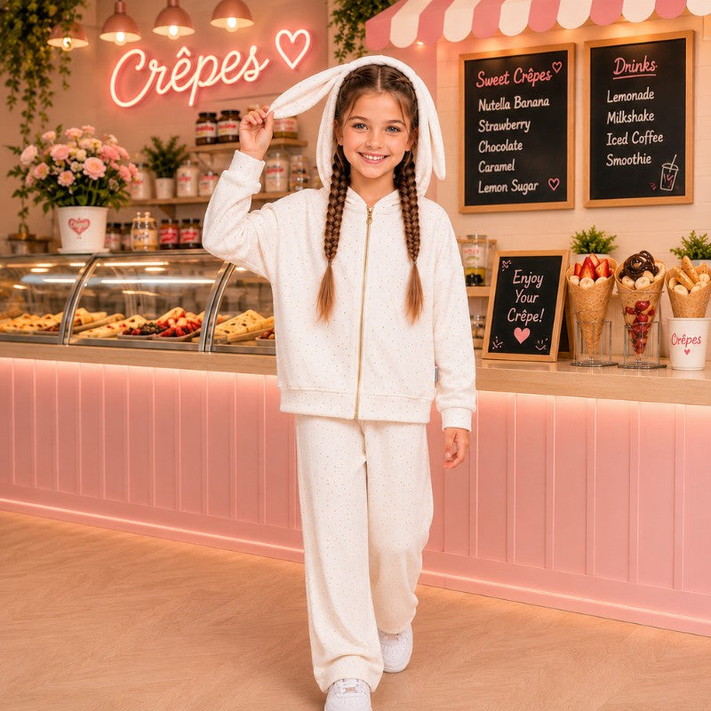 Young girl wearing a white bunny-ear hoodie tracksuit set in a pink crepe shop
