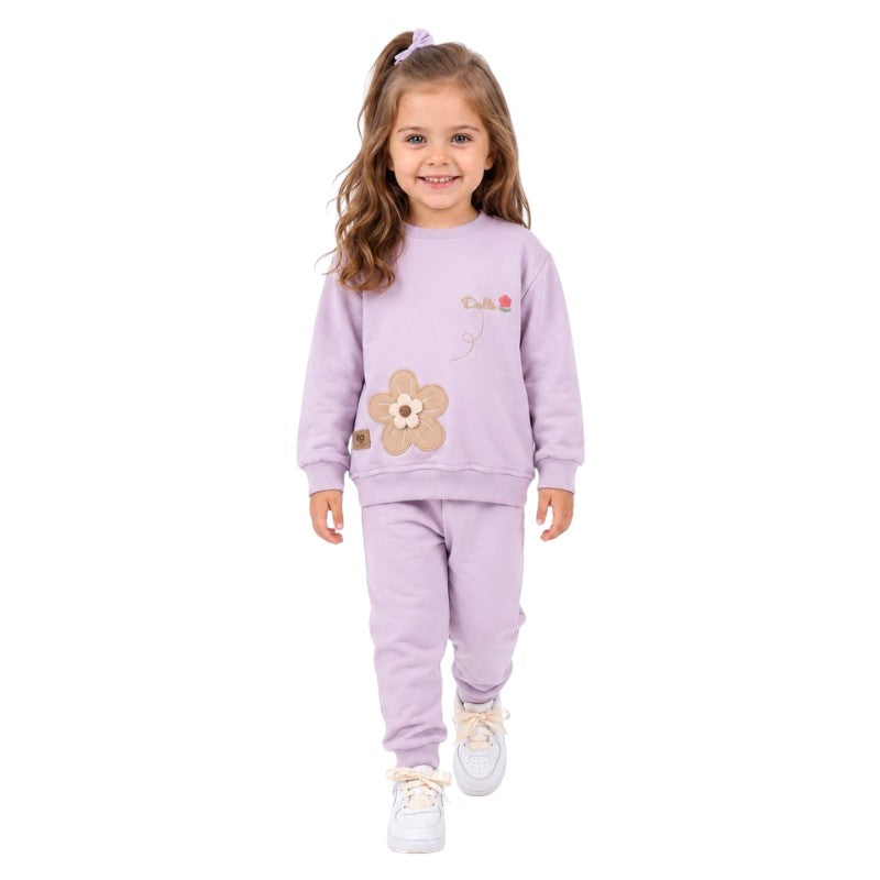 Smiling young girl wearing a lila floral sweatshirt and matching jogger tracksuit 