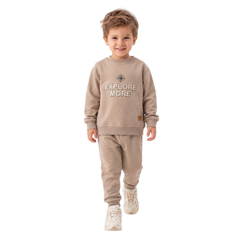 Smiling young boy wearing a  “Explore More” sweatshirt with matching jogger pants 