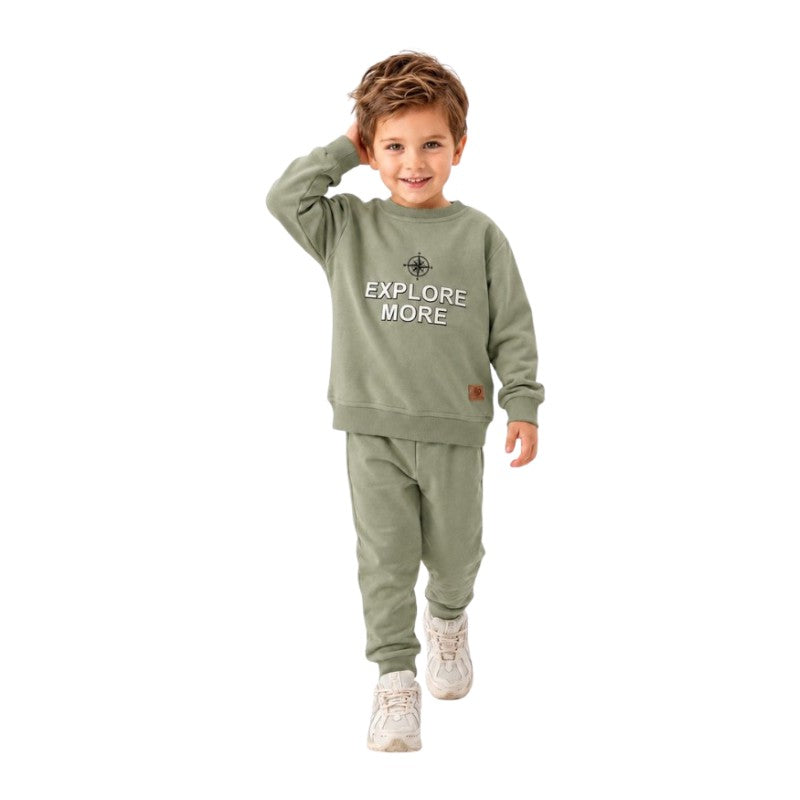 Smiling young boy wearing a  “Explore More” sweatshirt with matching jogger pants 