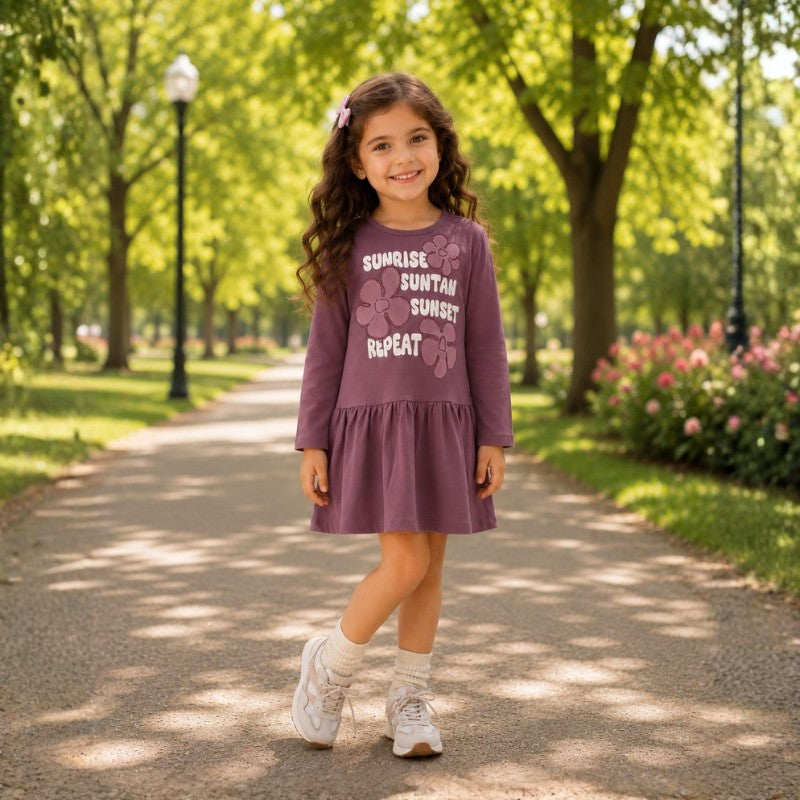 Young girl wearing a long sleeve dress with a floral graphic print 