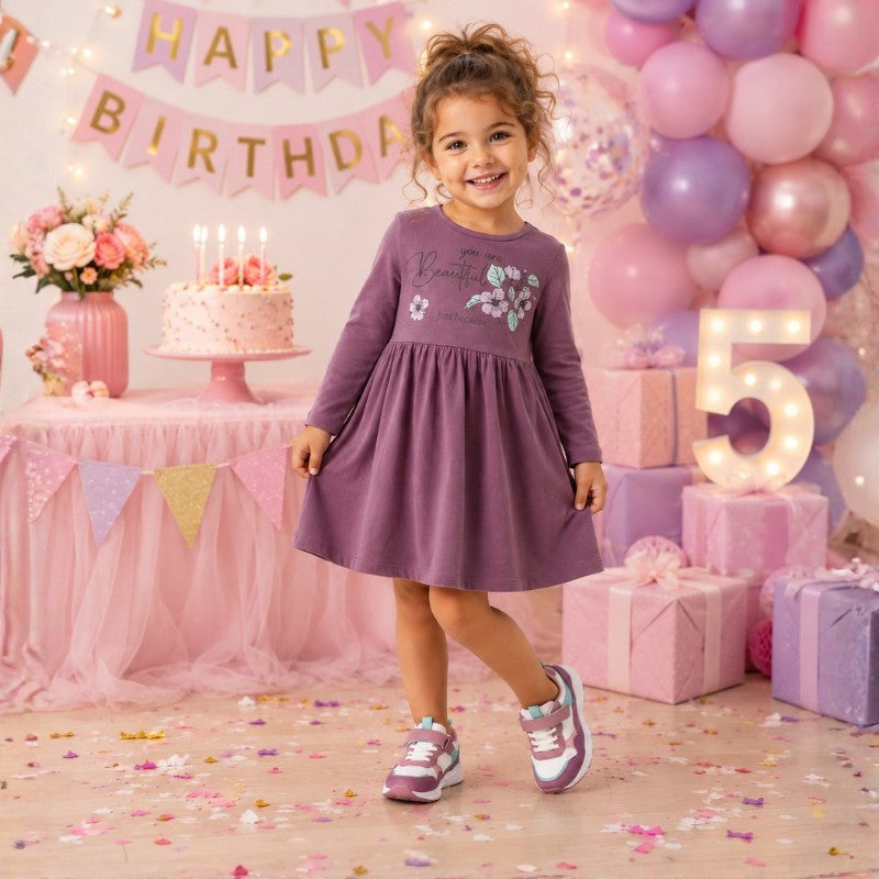 Young girl wearing a long sleeve dress with a floral print