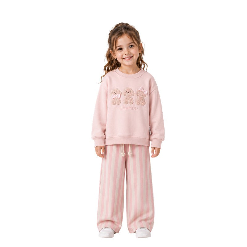 Young girl wearing a teddy bear sweatshirt with striped pants 