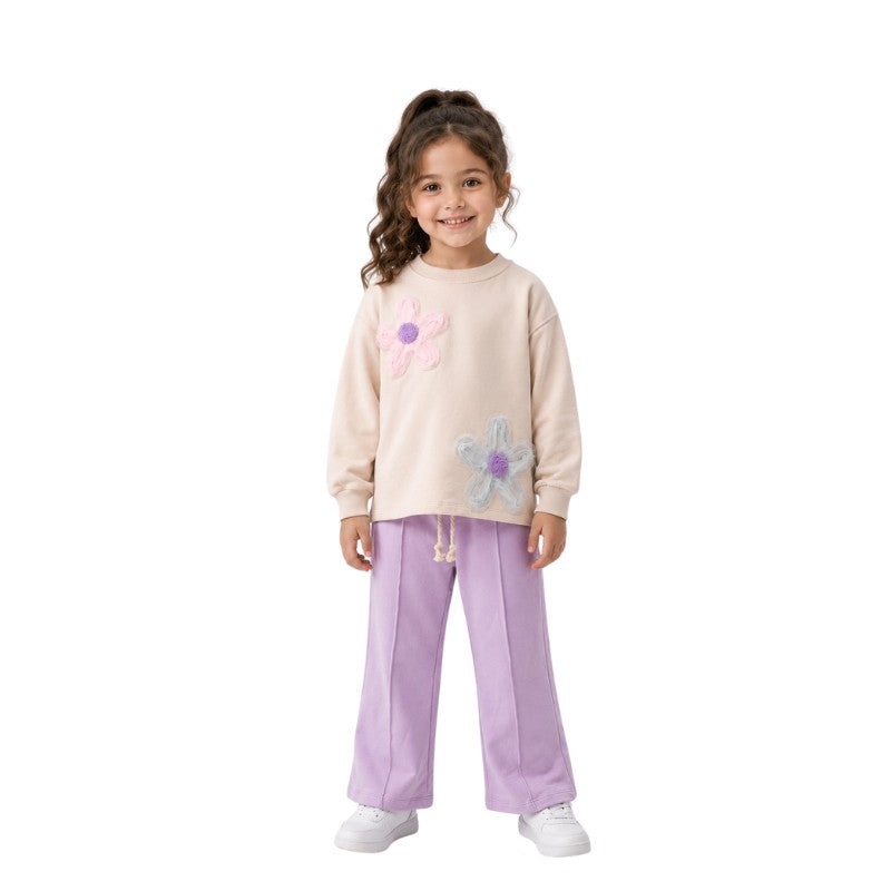 Young girl wearing a floral sweatshirt with wide-leg pants