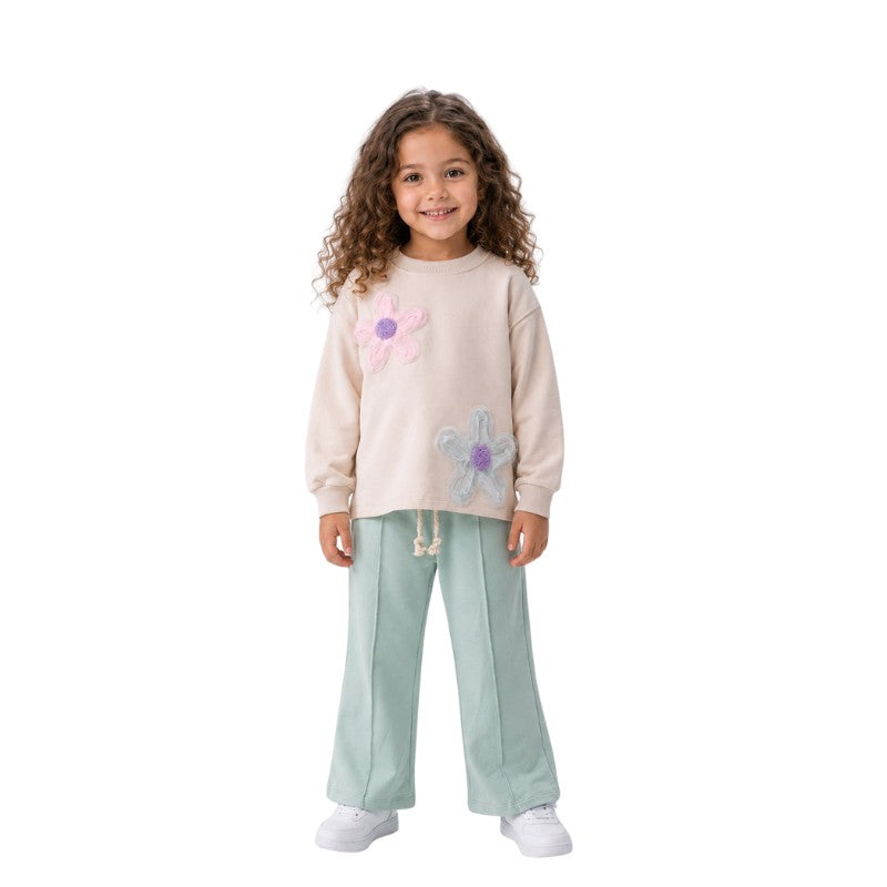 
Young girl wearing a floral sweatshirt with wide-leg pants