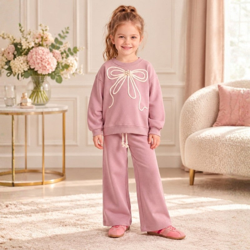 Girl wearing a pink bow sweatshirt with matching wide-leg pants