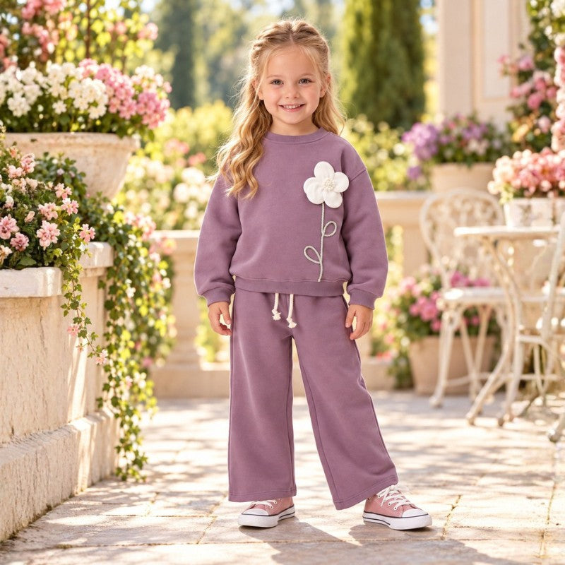 Girl wearing a mauve flower appliqué sweatshirt and matching wide-leg pants 