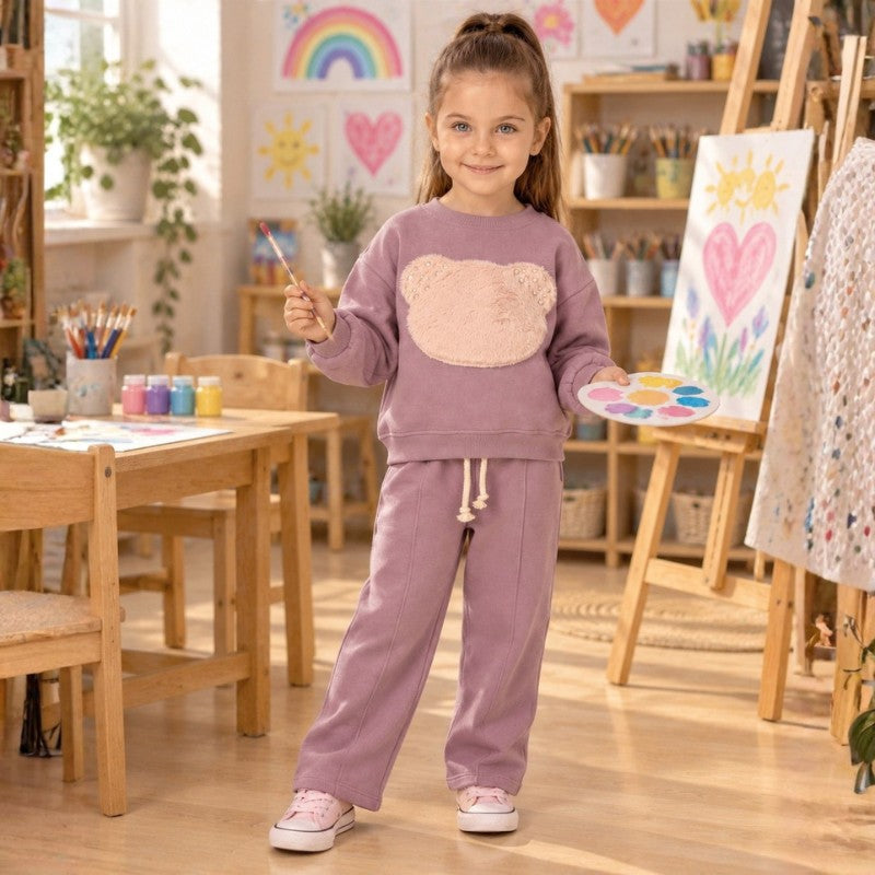 Girl wearing a fleece mauve teddy bear sweatshirt and matching pants 