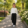 Young girl wearing a white sweatshirt with wide-leg pants 