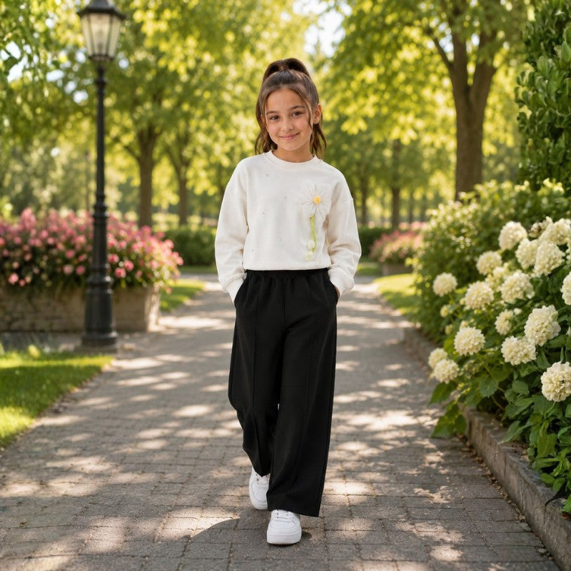 Young girl wearing a white sweatshirt with wide-leg pants 