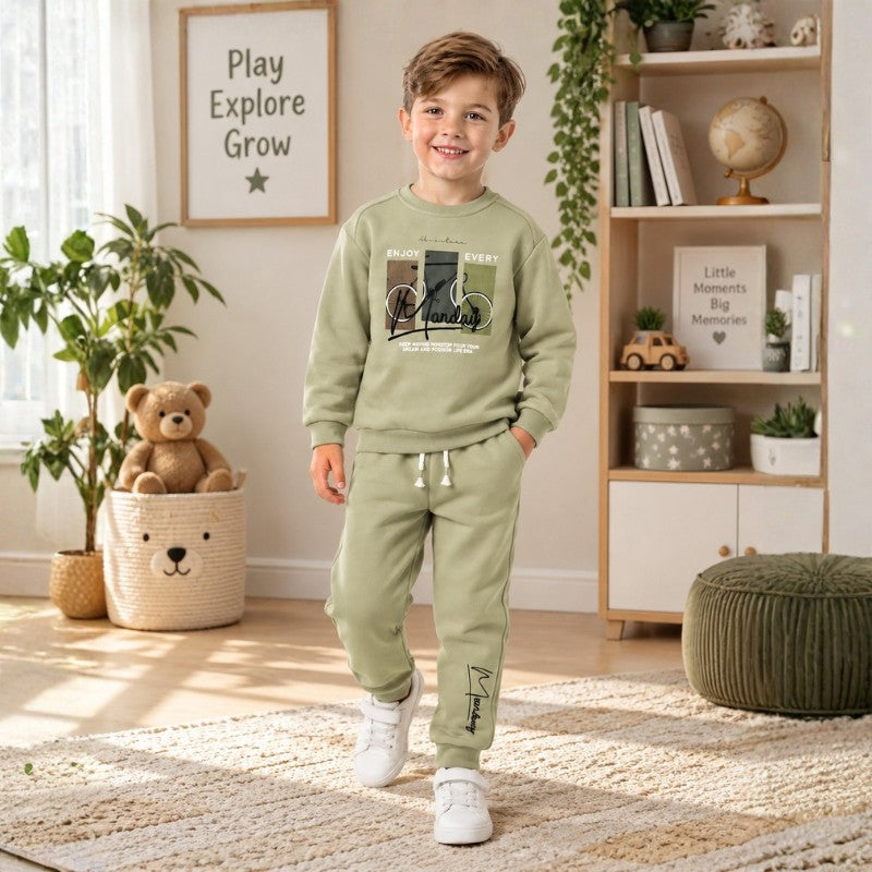 Young boy wearing a sage green sweatshirt with graphic print and matching jogger pants, a comfortable kids tracksuit set