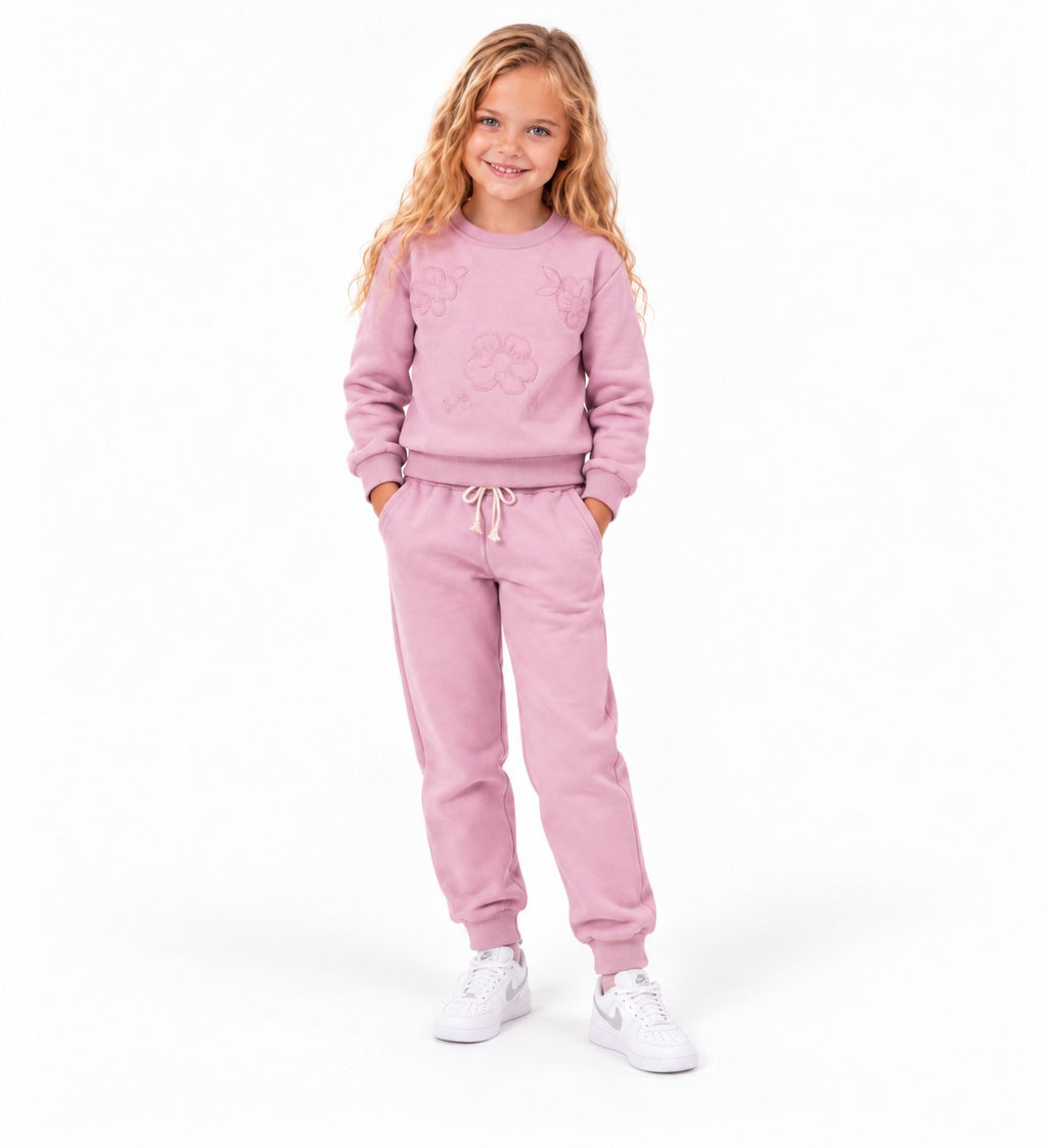 Girl wearing a soft pink sweatshirt and matching jogger pants, a comfortable casual tracksuit outfit for children