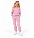 Girl wearing a soft pink sweatshirt and matching jogger pants, a comfortable casual tracksuit outfit for children