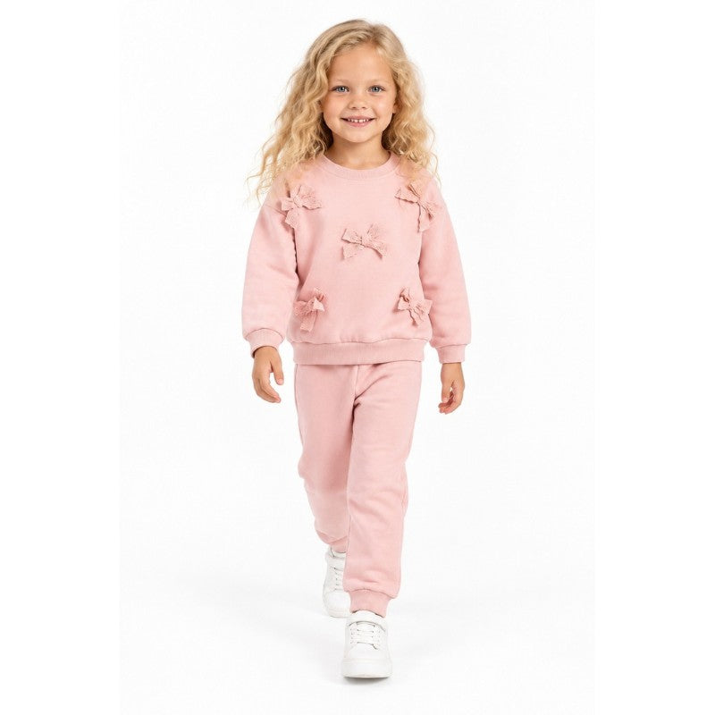 Young girl wearing a soft pink sweatshirt with bow details and matching jogger pants, a comfortable children’s casual outfit