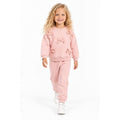 Young girl wearing a soft pink sweatshirt with bow details and matching jogger pants, a comfortable children’s casual outfit