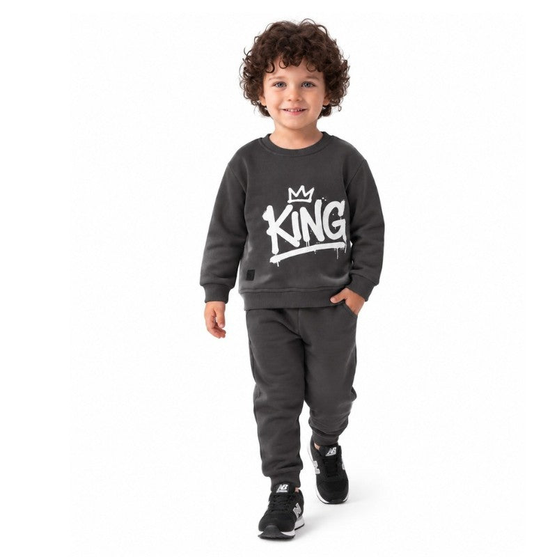 Young boy wearing a King graphic sweatshirt with matching jogger pants, a trendy kids casual tracksuit outfit