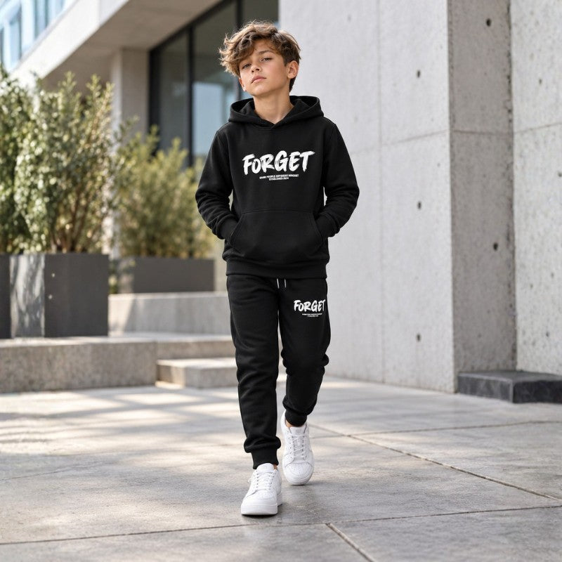 Stylish young boy wearing a black hoodie and jogger tracksuit set