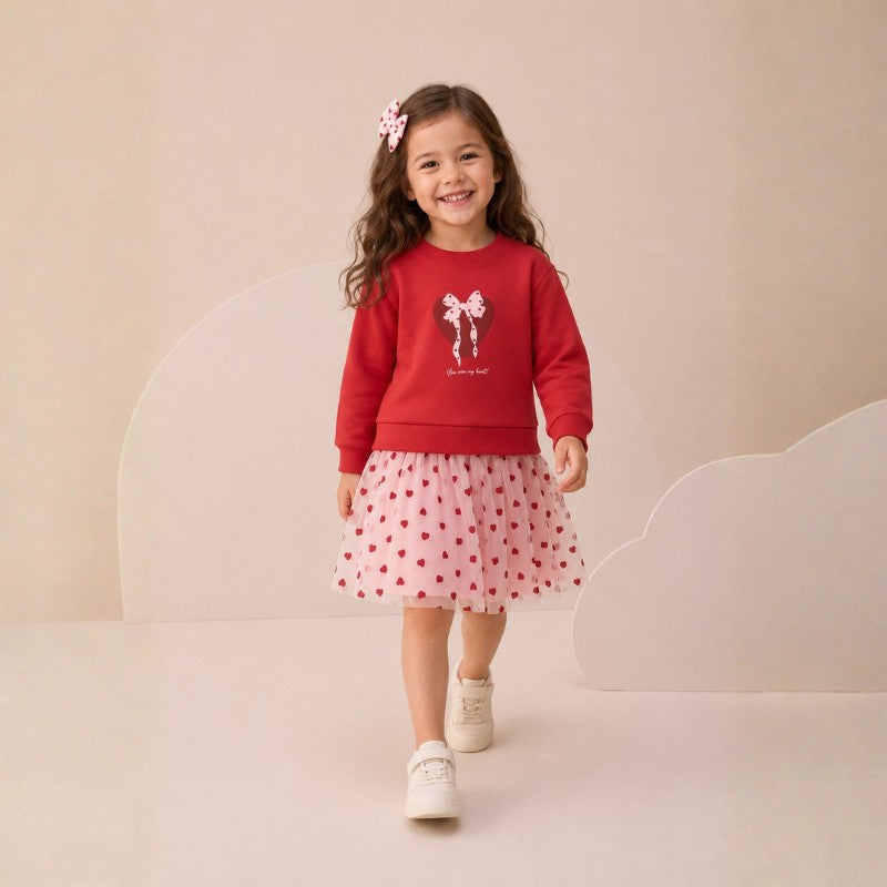 Girl wearing a  bow sweatshirt and red heart-print tulle skirt