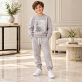 Boy wearing a grey graphic sweatshirt and matching joggers 