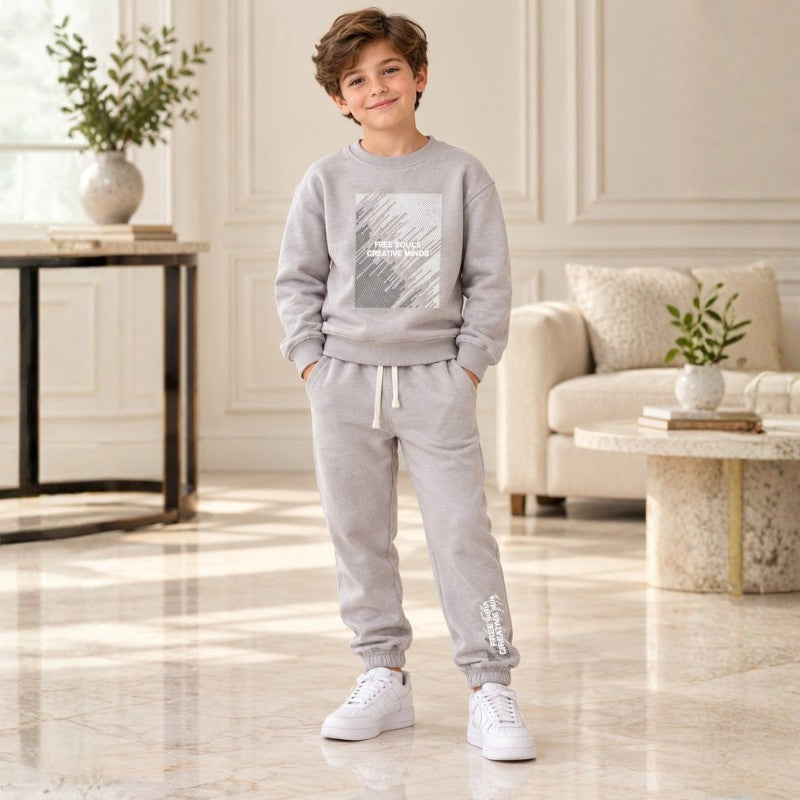 Boy wearing a grey graphic sweatshirt and matching joggers 