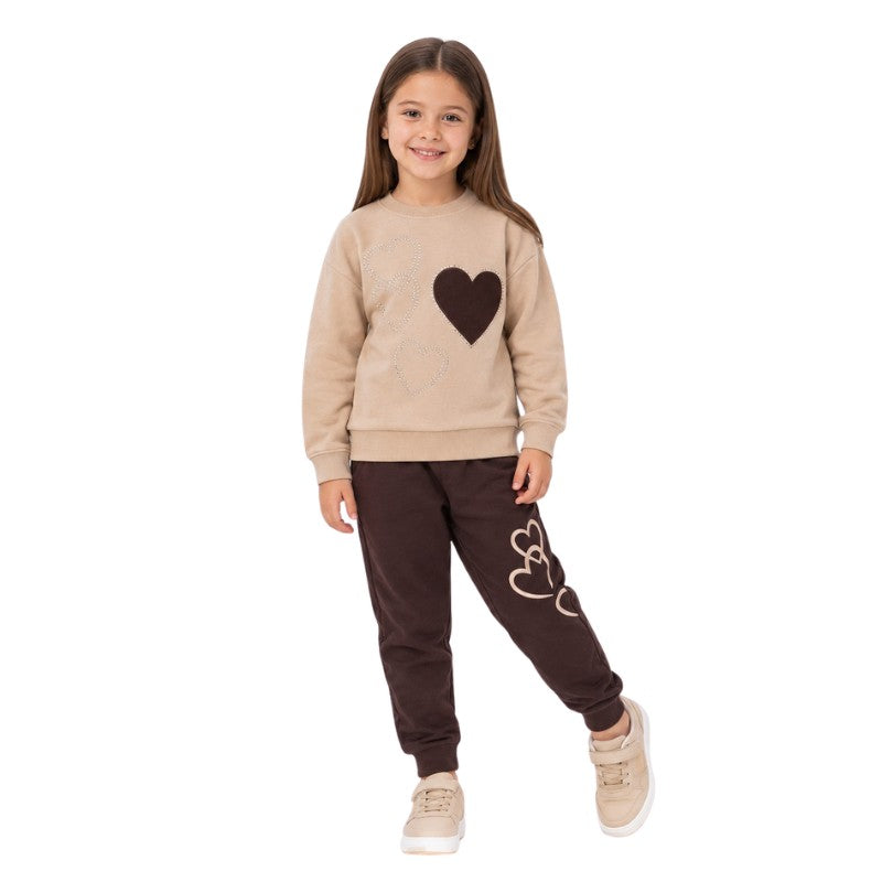 Young girl wearing a cream heart-print sweatshirt and jogger pants 