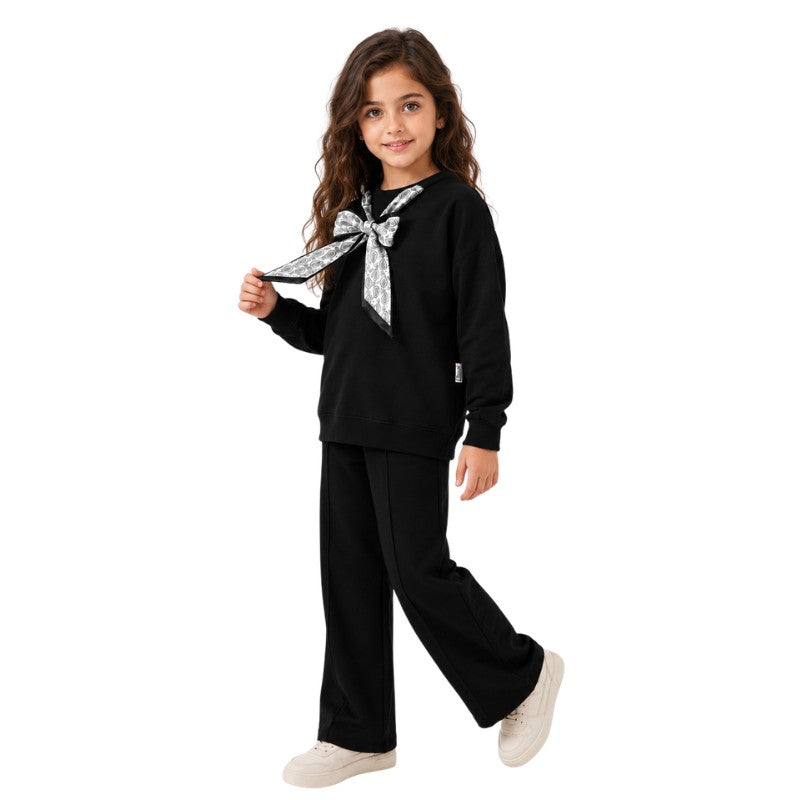 Young girl wearing a black butterfly bow tracksuit set 