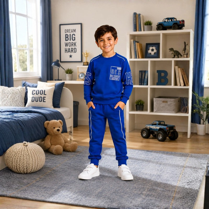 Smiling young boy wearing a graphic sweatshirt with matching jogger pants 
