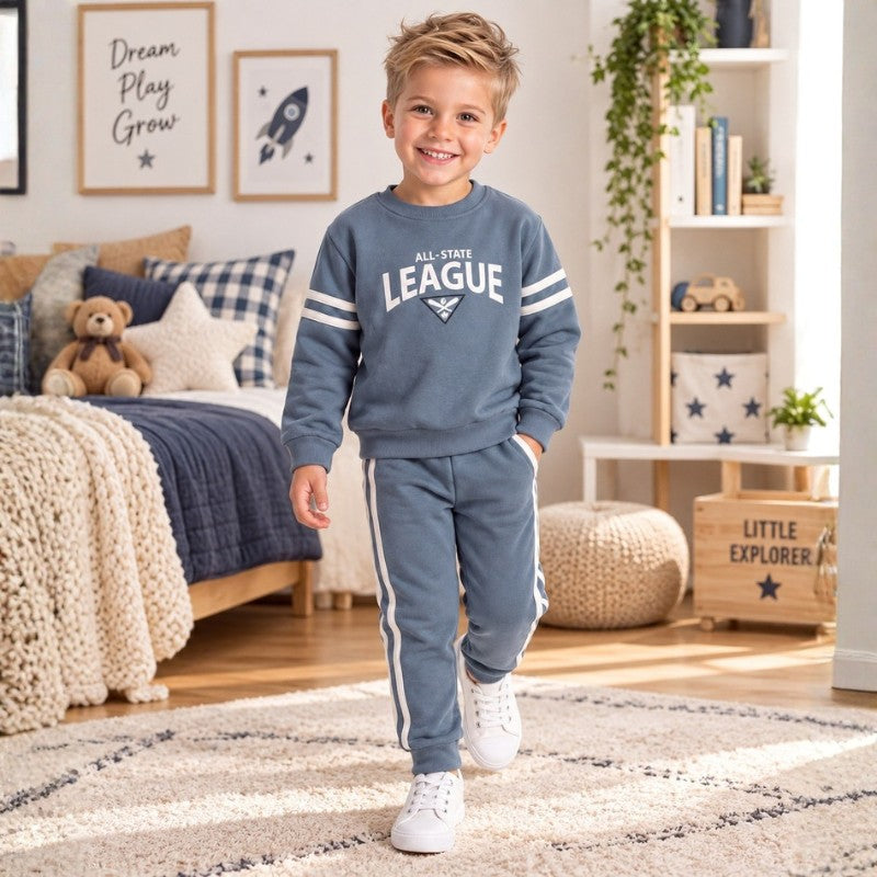Young boy wearing a blue All-State League sweatshirt with matching striped jogger pants, stylish casual kids tracksuit