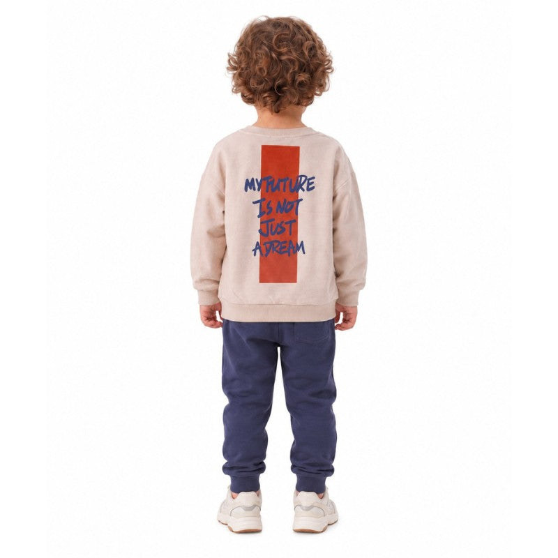 Young boy shown from behind wearing a taupe graphic sweatshirt with navy joggers  