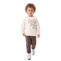 Young boy wearing graphic sweatshirt and brown jogger pants.