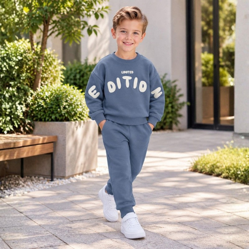 Boy wearing a sweatshirt with Limited Edition graphic and matching jogger pants, stylish casual kids tracksuit