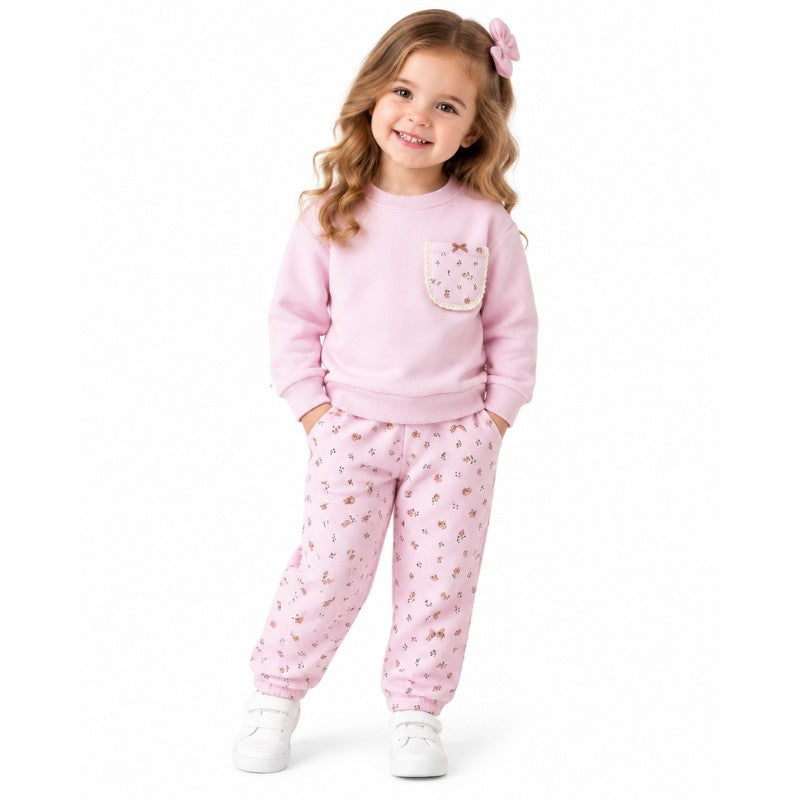 Young girl wearing a pink floral pocket sweatshirt and matching printed joggers 