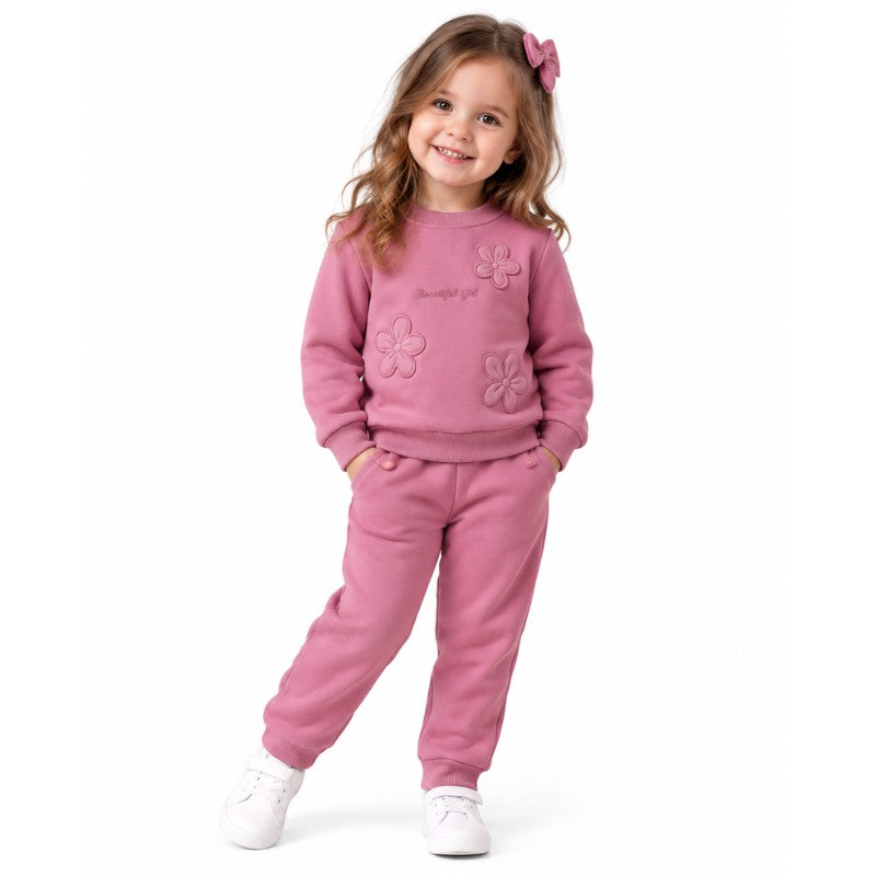 Young girl wearing a dusty pink floral appliqué sweatshirt with matching jogger trousers