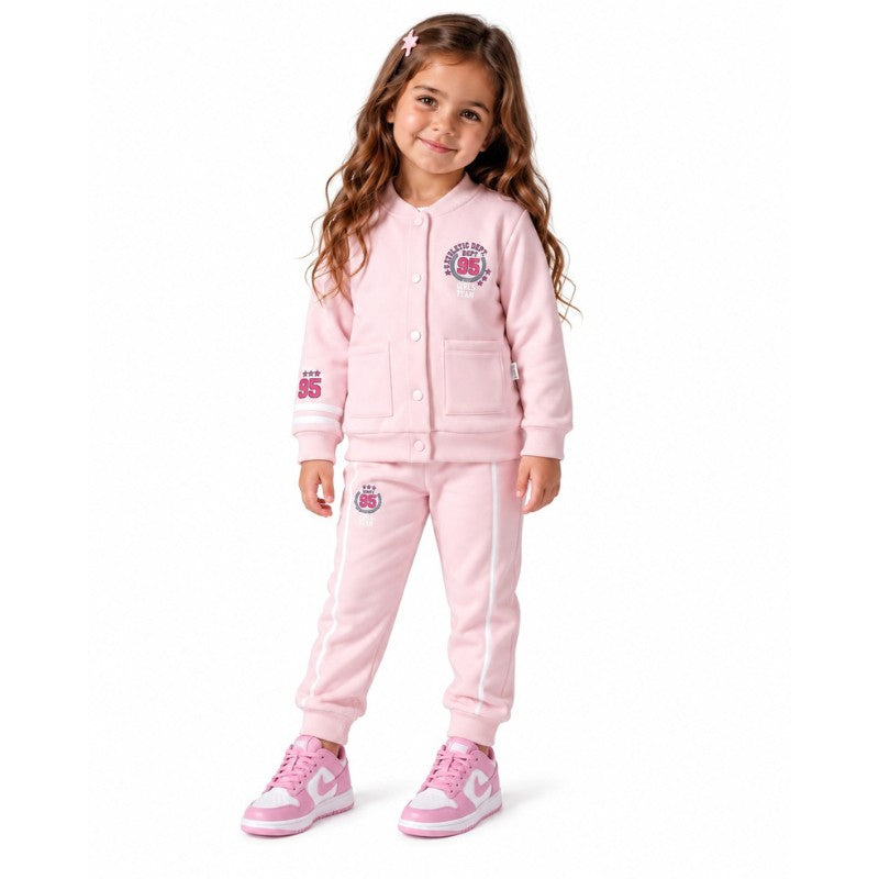 Young girl wearing a light pink varsity jacket with number 95 graphics and matching striped jogger trousers