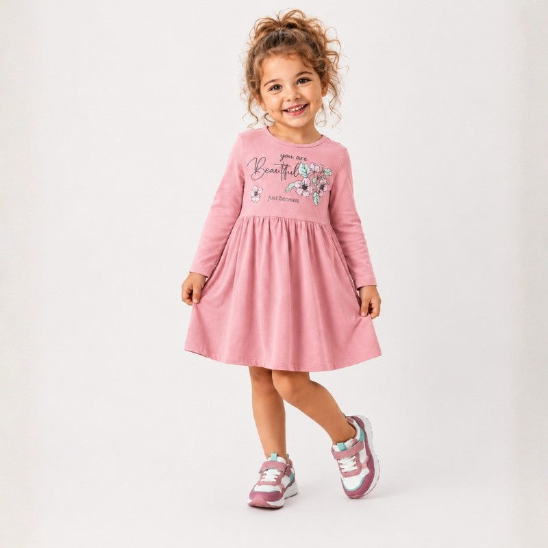 Young girl wearing a long sleeve dress with a floral print