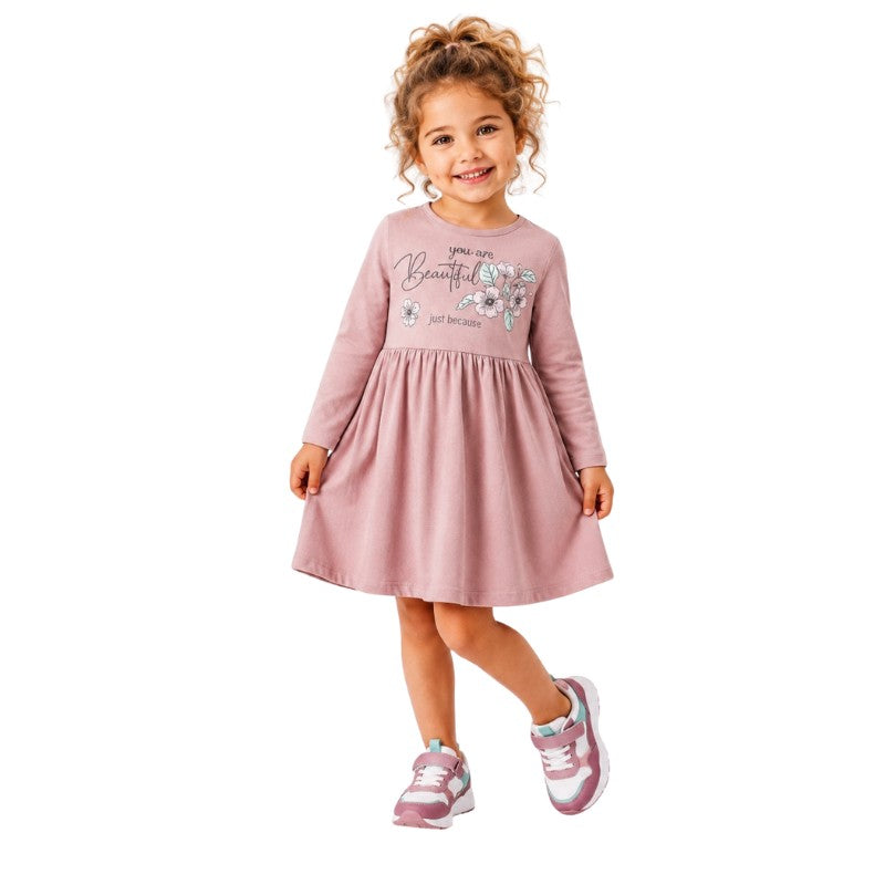 Young girl wearing a long sleeve dress with a floral print