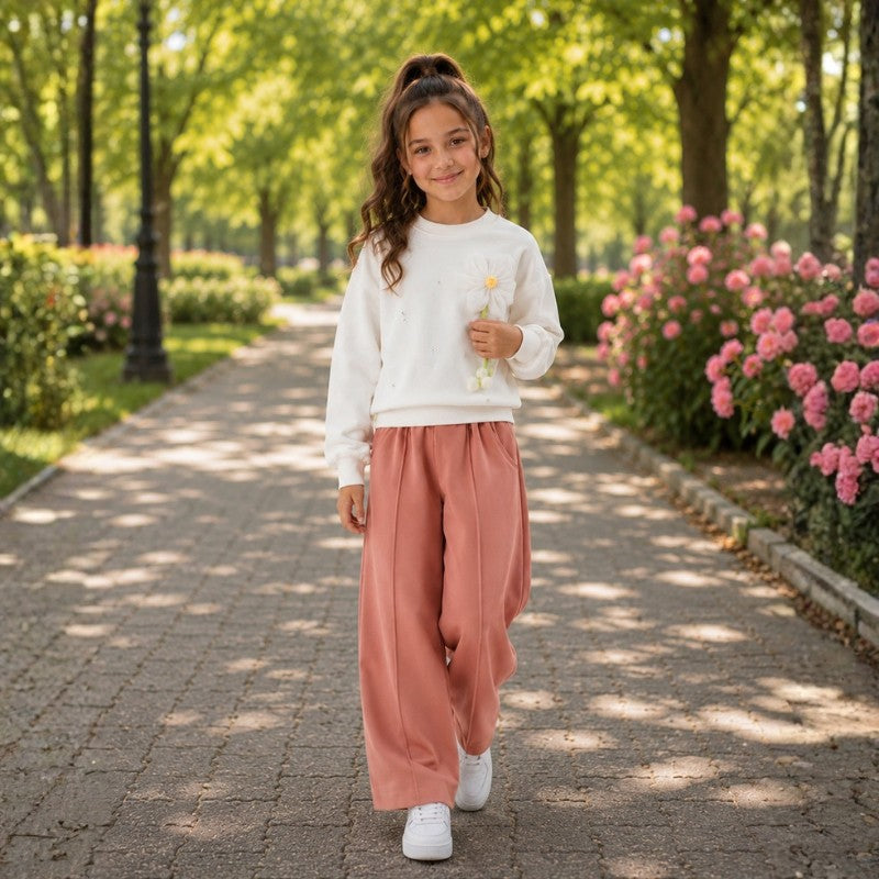 Young girl wearing a white sweatshirt with wide-leg pants 