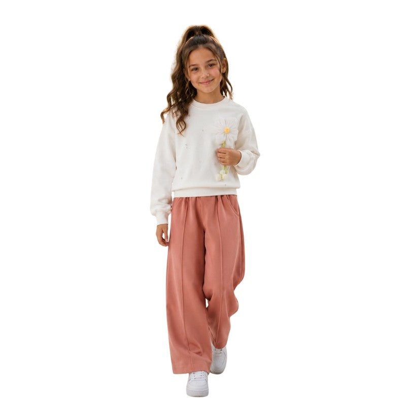 Young girl wearing a white sweatshirt with wide-leg pants 