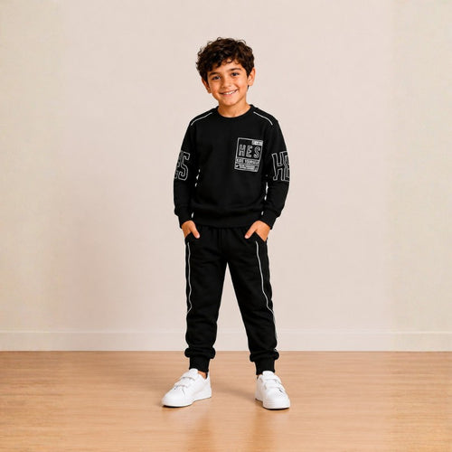 Smiling young boy wearing a graphic sweatshirt with matching jogger pants