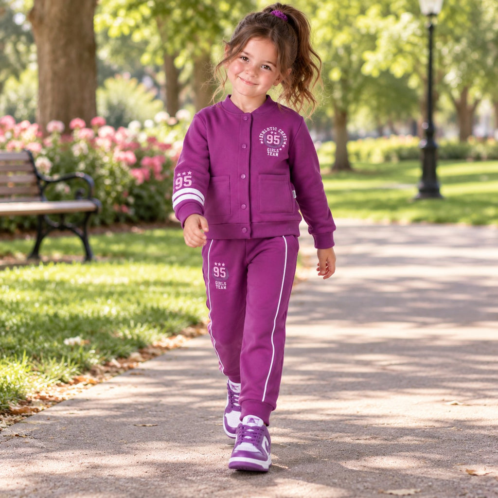 Young girl wearing a varsity jacket with number 95 graphics and matching striped jogger trousers