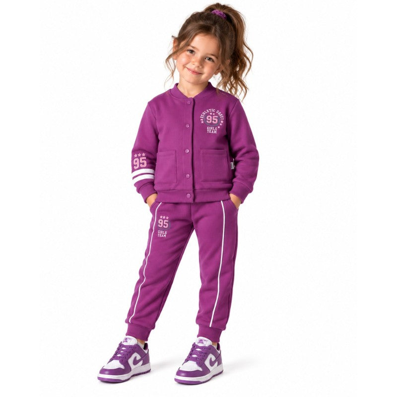 Young girl wearing a varsity jacket with number 95 graphics and matching striped jogger trousers