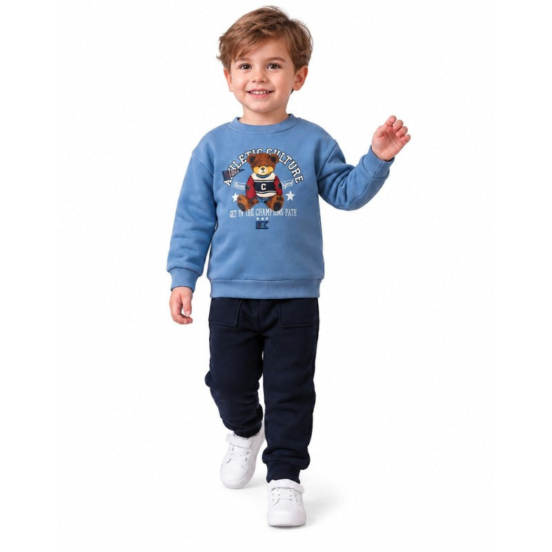 Young boy wearing a light blue teddy bear sweatshirt and navy pants