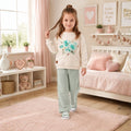 Girl wearing a cream floral sweatshirt with wide-leg pants