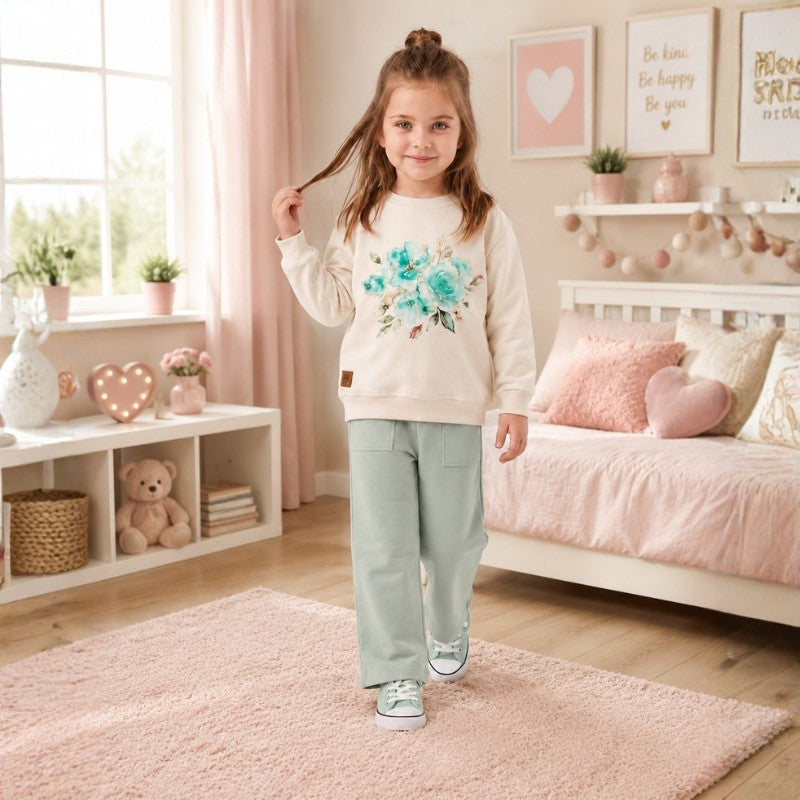 Girl wearing a cream floral sweatshirt with wide-leg pants