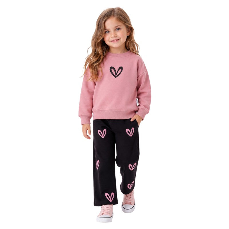 Young girl wearing a sweatshirt with a heart graphic and jogger pants featuring pink heart prints, stylish children's two-piece outfit.