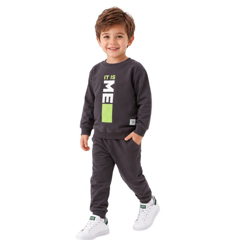 Smiling young boy wearing a “It Is Me” graphic sweatshirt with matching jogger pants 